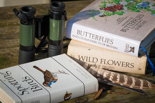 Binoculars and field guides to birds, butterflies and wild flowers